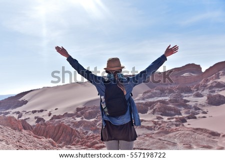 Traveling woman in hat with raised hands. Valley of the Moon. Atacama Desert. Chile
