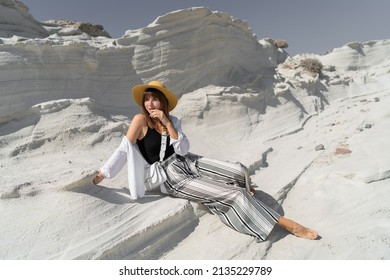 Traveling Woman In Straw Hat Posing  Over White Stone Landscape On Delkikli Koy In  Aegean Sea. 