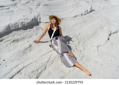 Traveling Woman In Straw Hat Posing  Over White Stone Landscape On Delkikli Koy In  Aegean Sea.  Full Lenght.