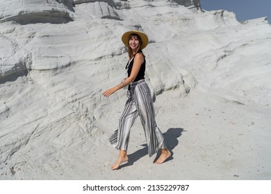 Traveling Woman In Straw Hat Walking   Over White Stone Landscape On Delkikli Koy In  Aegean Sea.  Full Lenght.