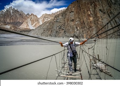 Traveller Crossing Dangerous Bridge Over Hunza River In Karakorum In Pakistan