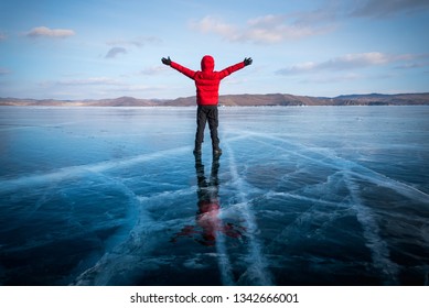 Traveller man raise up hand freedom and enjoy view of beautiful landscape natural breaking ice in frozen water at Lake Baikal, Siberia, Russia. Travel or Freedom concept.