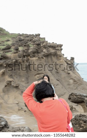 The traveller is standing among the strange rock mountain and taking a photo for their vacation, beautiful view 