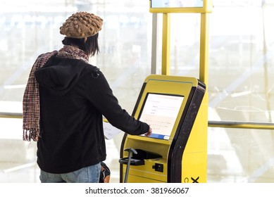 A Traveller Using Self Service Check In Machine At Airport