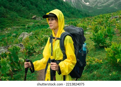 Traveller Woman In Yellow Raincoat Walking In Mountain Valley In Rainy Day. City Escape