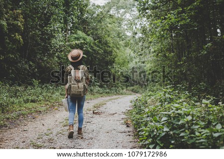traveller women walking on road in the forest