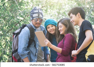 Travellers group with smile reading map in taplet feeling happy in national park