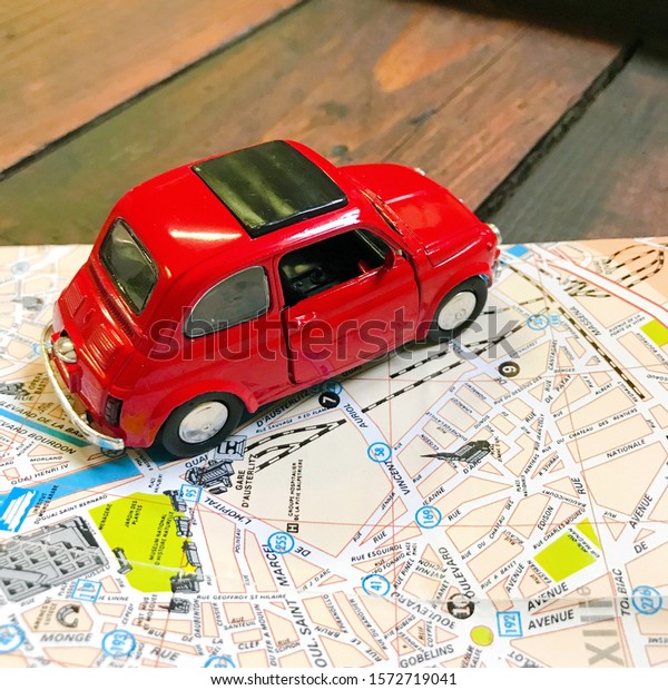 Travelling by car. Toy car model on top on a road\
map. Place for text.