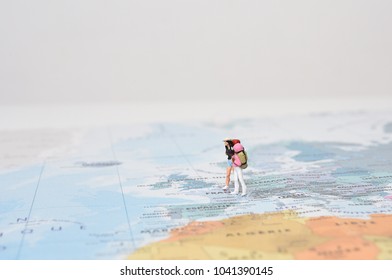 Travelling concepts. Group of traveler miniature mini figures with backpack standing and walking on world map - Shutterstock ID 1041390145