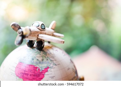 Travelling concepts. Retro Airplane miniature mini figures standing on globe world map balloon, travel around the world and Airline plane tourist agency business background