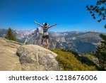 Travelling enthusiast woman happy for the Glacier Point aerial view in Yosemite National Park, California, US. Glacier Point panorama: Half Dome, Liberty Cap, Yosemite Valley, Vernal Fall, Nevada Fall