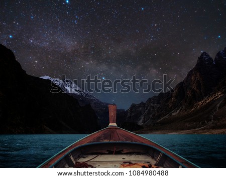 Travelling on lake at night by boat, sky full of star and milky way with mountains valley