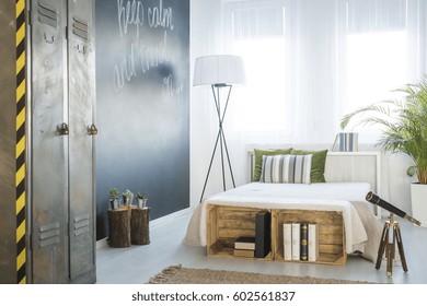 Travel-themed Bedroom Interior With Chalkboard Wall, Telescope And Locker