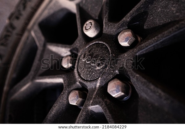 Traverse City, Michigan, USA - July 20 2022:\
Dirt, mud, and dust on black metal alloy wheel of Jeep Wrangler\
texture background. Logo\
close-up.