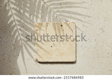 Travertine stone display flat lay podium on travertine stone background and palm shadow. Product promotion Beauty cosmetic showcase.