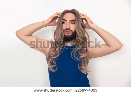 Travesty man fixing his fake long hair