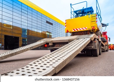 Trawl Transport Special Machines. Loading Of Special Equipment On The Tow Truck With The Help Of Ladders. Aluminum Ramps For Vehicles. Trawl With Aluminum Ramps. Transportation Of Oversized Cargo.