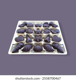 A tray of assorted chocolates shaped like seashells and other patterns displayed on a centered grey background. Represent dessert, indulgence, celebration, and gifting occasions for any celebration.