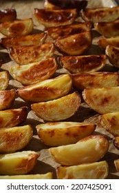 A tray of baked potato wedges  - dark moody food photography - Shutterstock ID 2207425091