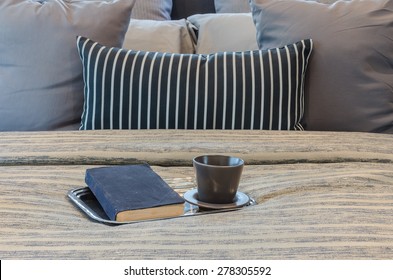 tray of books and cup on bed at home