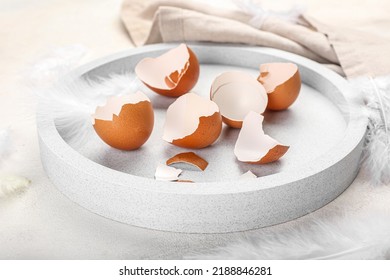 Tray with broken egg shells on table, closeup