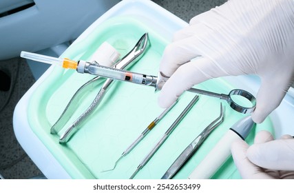 tray of dentistry elements. Hand of dentist taking anesthesia syringe for dentistry. Dentistry anesthesia medication. Local anesthesia. Instrumental dentistry tray. Closed angle, close-up. - Powered by Shutterstock