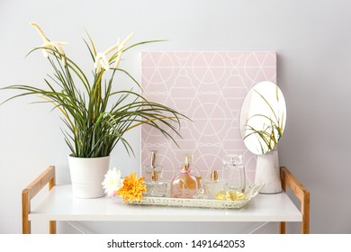 Tray with different perfumes on table in room