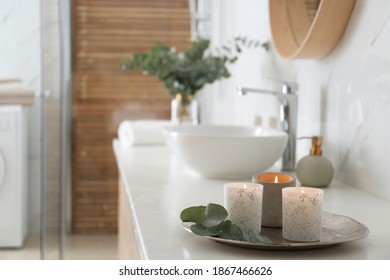 Tray With Eucalyptus Leaves And Burning Candles On Countertop In Bathroom