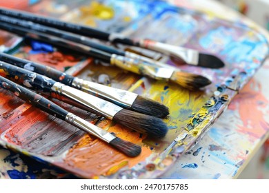 Tray filled with paintbrushes and watercolor palettes, set up for an art lesson. - Powered by Shutterstock