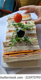 Tray Of Finger Sandwiches For High Tea With Hand Picking One