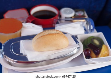 Tray Of Food On The Plane. Focus On A Bun.