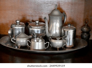 tray full of silver pewter objects, the background is wooden

