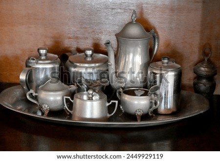 tray full of silver pewter objects, the background is wooden

