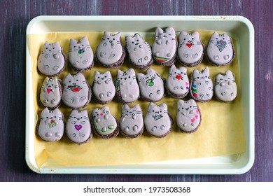 Tray of homemade vegan macaron cookies shaped like a cartoon cat