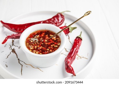 Tray with hot honey and dry chili peppers on light wooden background - Powered by Shutterstock