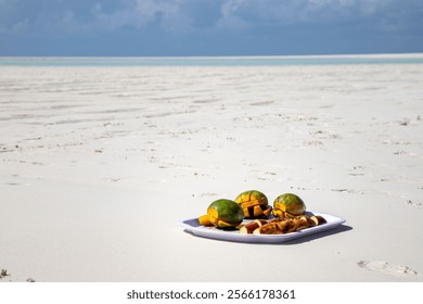 A tray with refreshments, fresh mango and bananas, placed on the bright sands of a shallow area near Mnemba Island, Zanzibar (Unguja), Tanzania. Azure waters of the Indian Ocean near coral reef. - Powered by Shutterstock