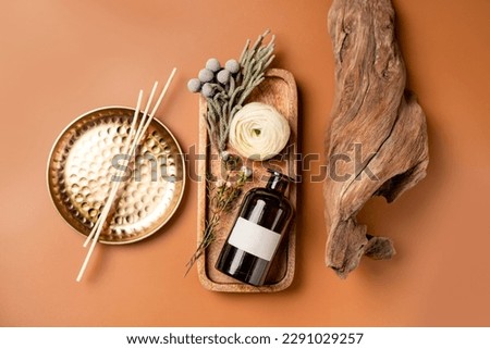 Tray with scented home perfume in glass jar with rattan sticks. Luxury aroma oil home fragrance with woody and flowers notes concept.