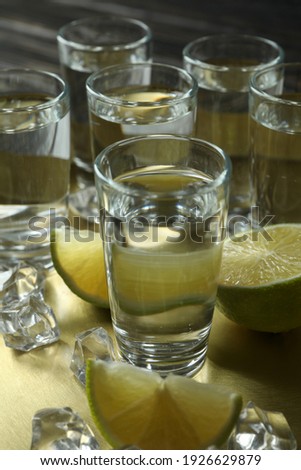 Tray with shots, lime slices and ice cubes, close up