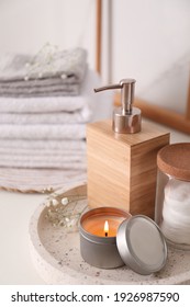 Tray with soap dispenser, cotton pads and burning candle on countertop in bathroom - Shutterstock ID 1926987590