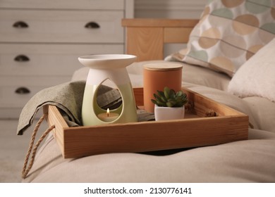 Tray with stylish aroma lamp and houseplant on sofa in room - Shutterstock ID 2130776141