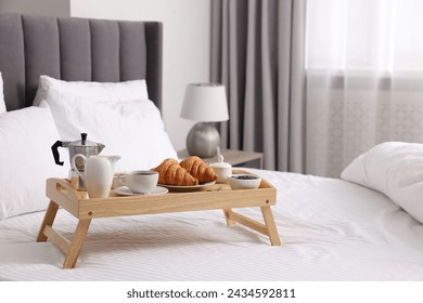 Tray with tasty breakfast on bed at home, space for text - Powered by Shutterstock