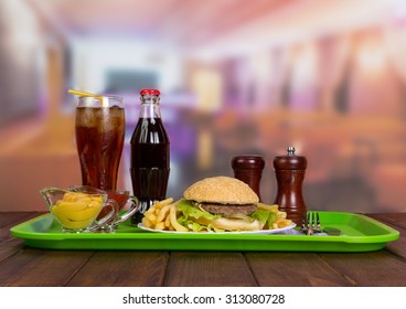 Tray of tasty hamburger with french fries and cola in glass
