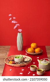 Tray With Traditional Tet Snacks, Tea And Ripe Mandarins On Table Covered With Red Cloth