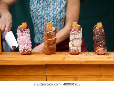 Trdelnik is street food of Prague. It considered a traditional national Czech sweet food. Trdlo is tubes of sweet dough, cooked on an open fire. The photo shows the 4 types of this dessert.