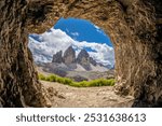 Tre Cime di Lavaredo, Drei Zinnen three peaks towers the symbol of the Dolomites. Beautiful mountain peaks towering above the valley in Dolomiti Alps with some clouds around the summit