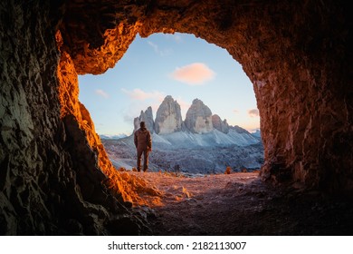 Tre Cime Di Lavaredo peaks in incredible orange sunset light. View from the cave in mountain against Three peaks of Lavaredo, Dolomite Alps, Italy, Europe. Landscape photography