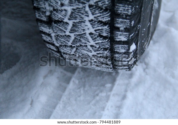 Tread\
area of winter tire packed with the snow close\
up\
