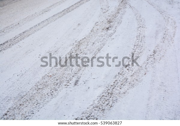 The tread marks
of car tires on winter
road.