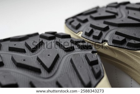 Tread pattern of two rubber soles of hiking shoes close up view 
