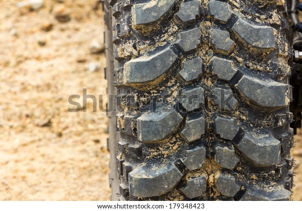 Tread tire coated in mud\
on an offroad